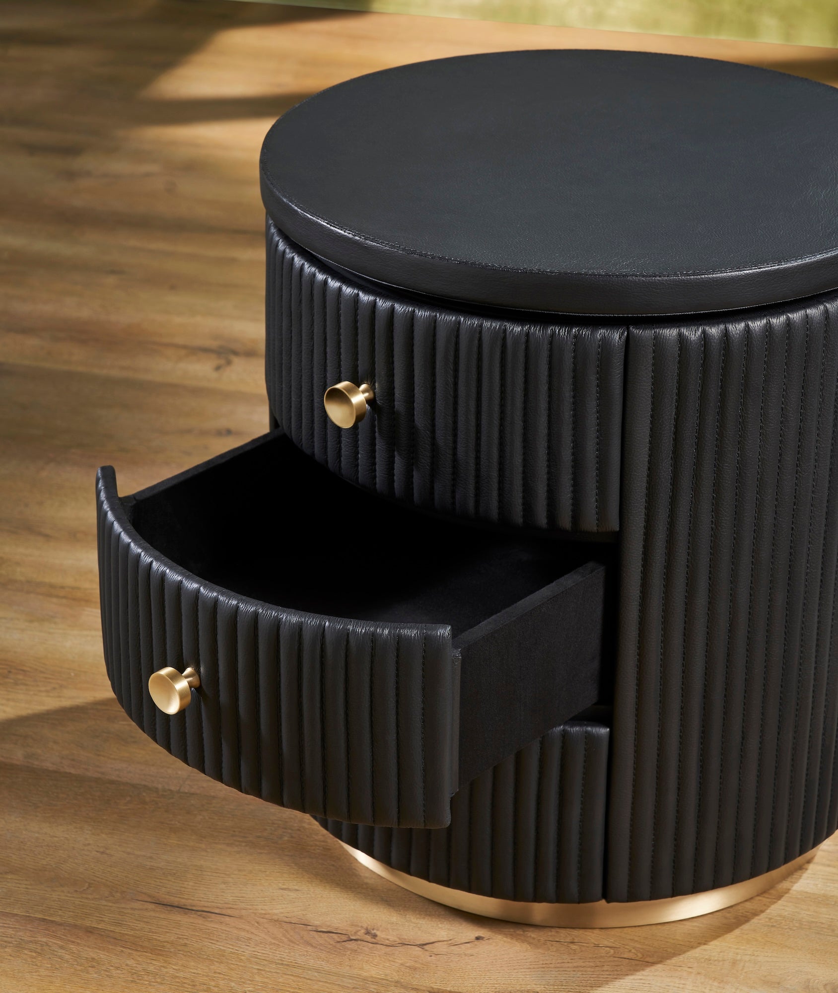 Stanford Round Fluted Leather Nightstand black drawer open fluted leather detail brass knobs brass rim base close up angled view hardwood floor