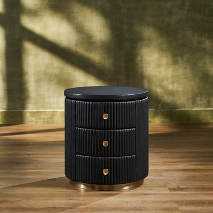 Stanford Round Fluted Leather Nightstand black three drawers brass knobs brass rim base front view warm green background hardwood floor