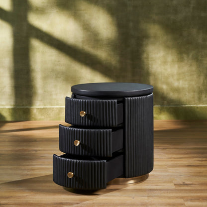 Stanford Round Fluted Leather Nightstand black three drawers open brass knobs brass rim base angled view golden wall hardwood floor