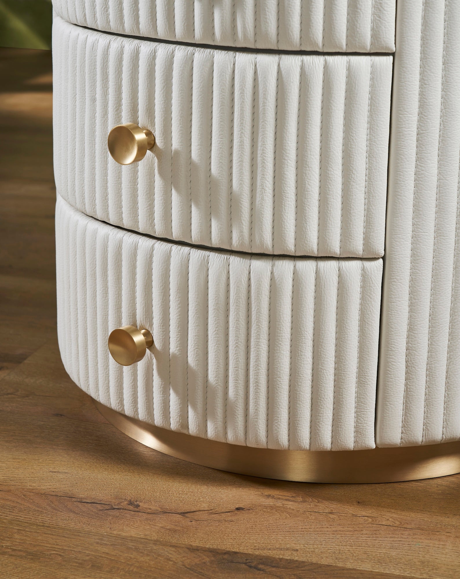 Stanford Round Fluted Leather Nightstand white brass knobs brass rim base drawers close up detail hardwood floor