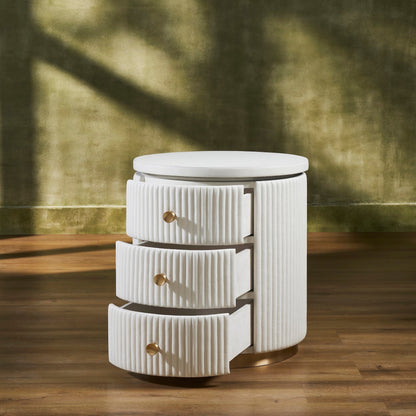 Stanford Round Fluted Leather Nightstand white three drawers open brass knobs brass rim base angled view golden wall hardwood floor