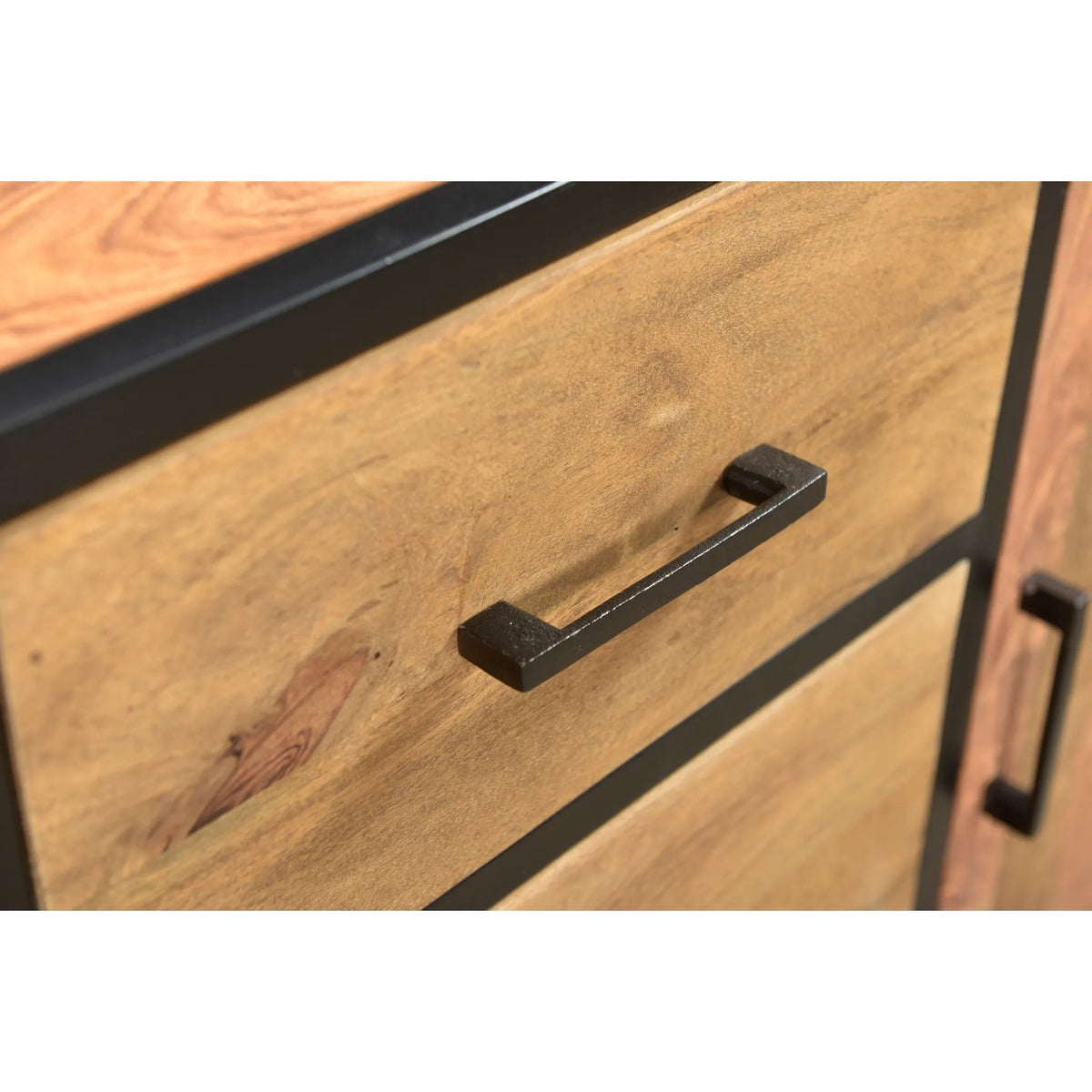 Close-up of Raven sheesham wood side board showing a black drawer handle, light brown wood grain, and black frame edging.