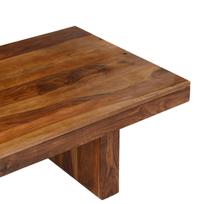 Close-up of solid seesham wood coffee table surface showing natural grain variation, warm brown tones, and chunky block leg construction with hand finished wax finish
