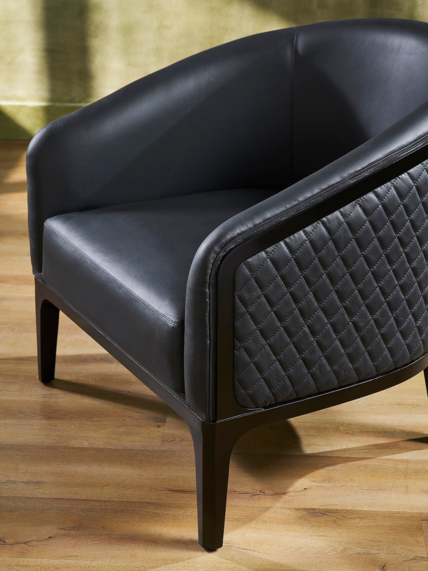 Top-Grain Leather Lounge Chair black close view diamond quilting curved arm hardwood legs detail