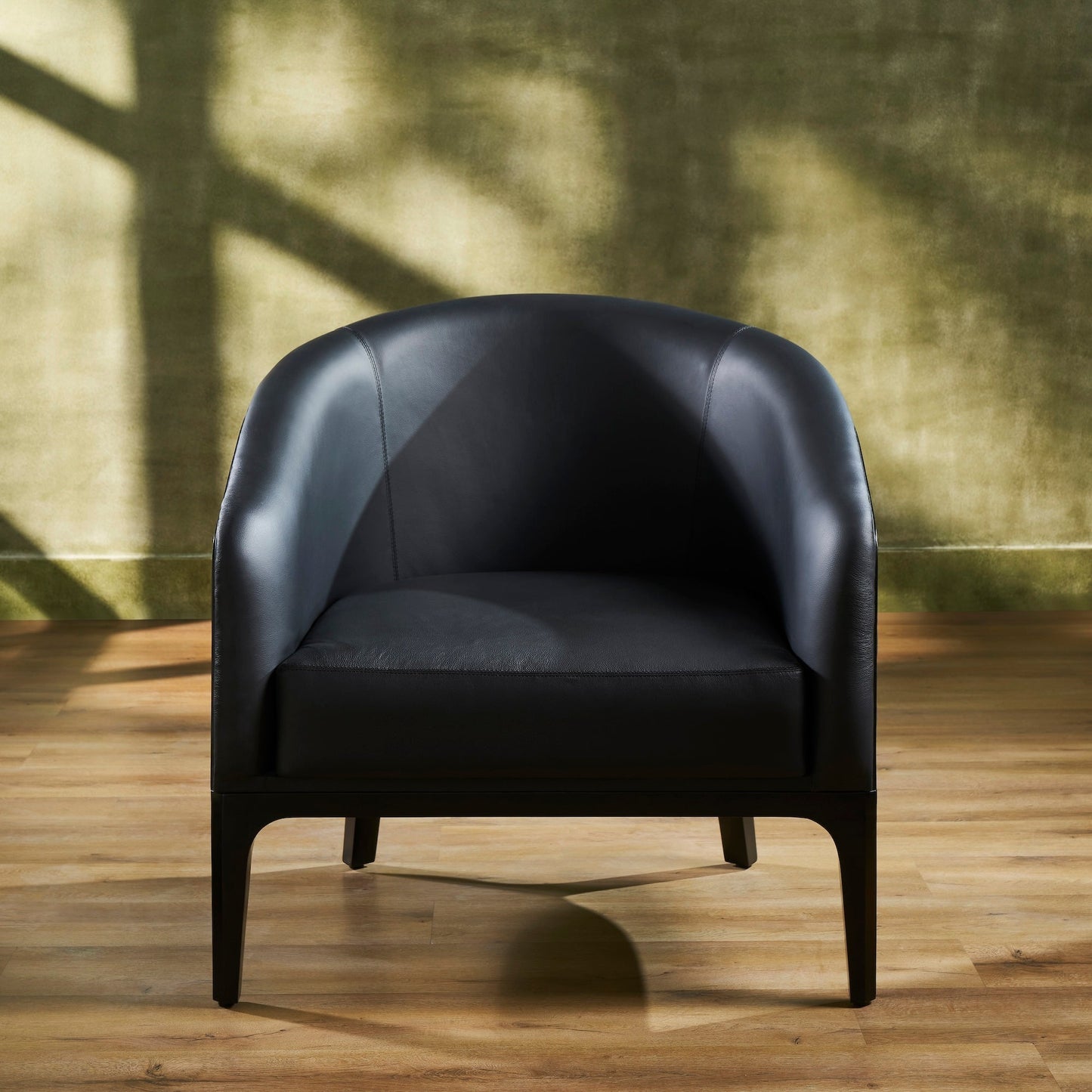Top-Grain Leather Lounge Chair black front view curved form hardwood legs natural light