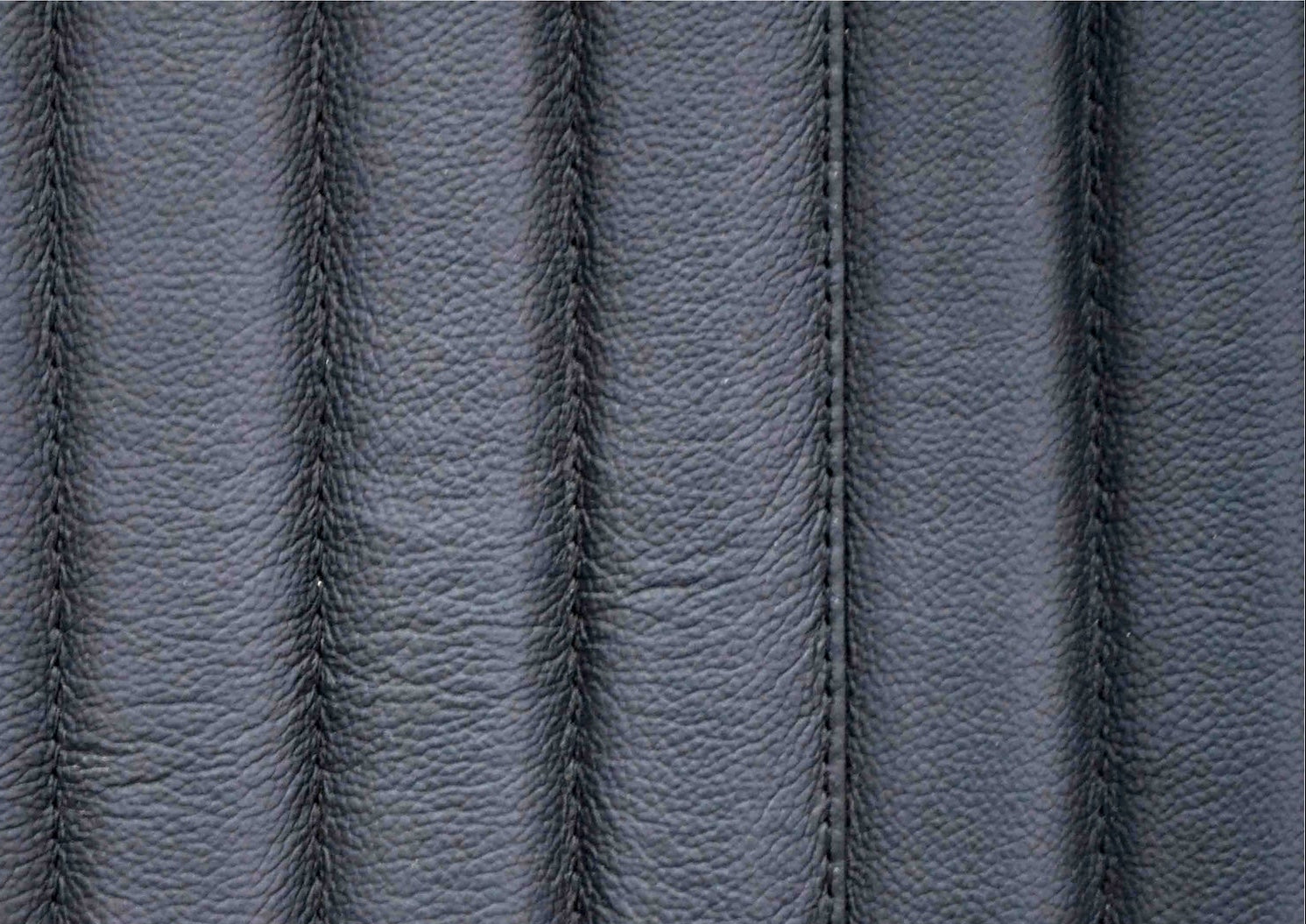 Top-grain leather lounge chair black genuine leather close texture natural grain detail 