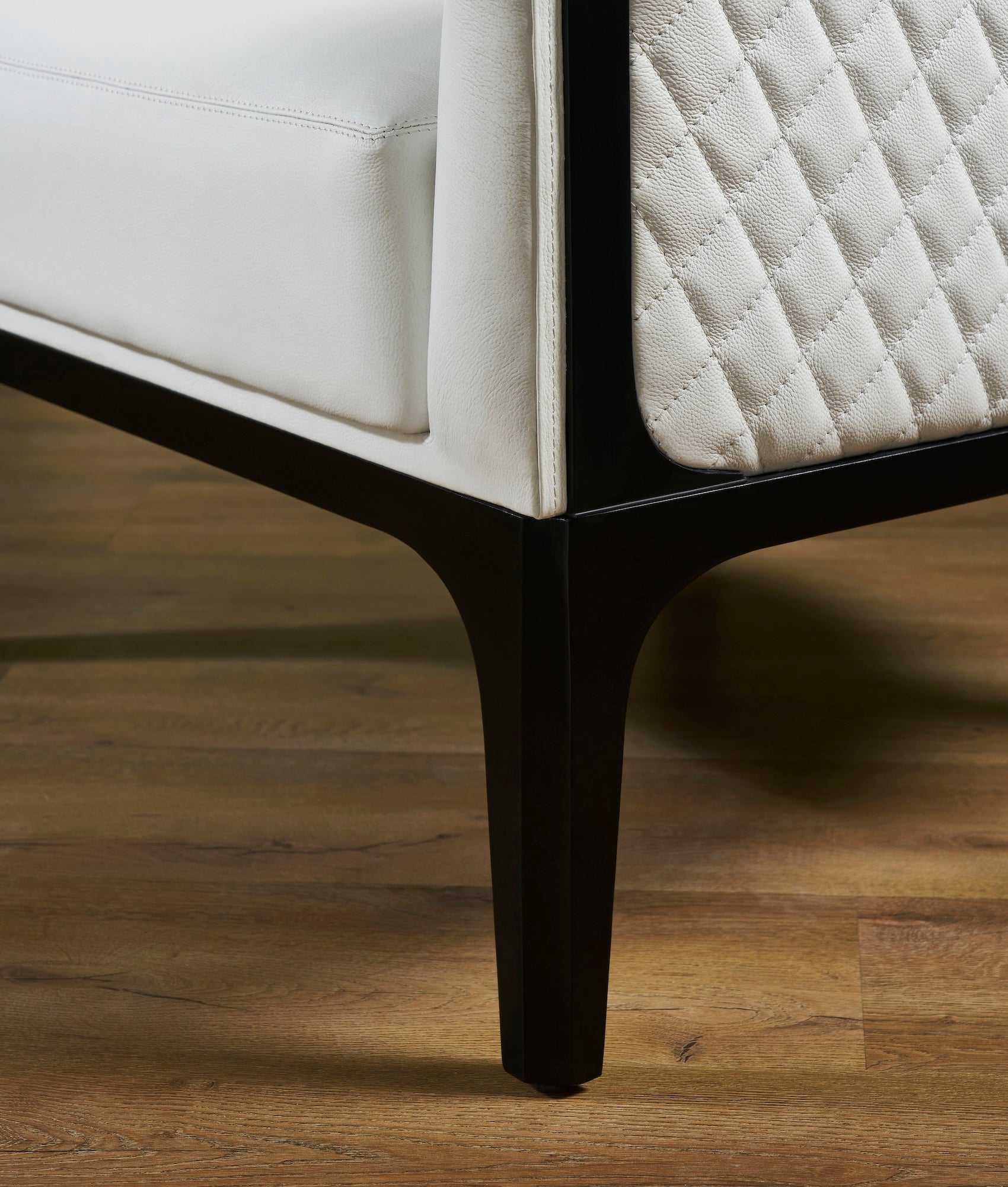 Top-Grain Leather Lounge Chair white solid hardwood leg detail diamond quilting close hardwood floor
