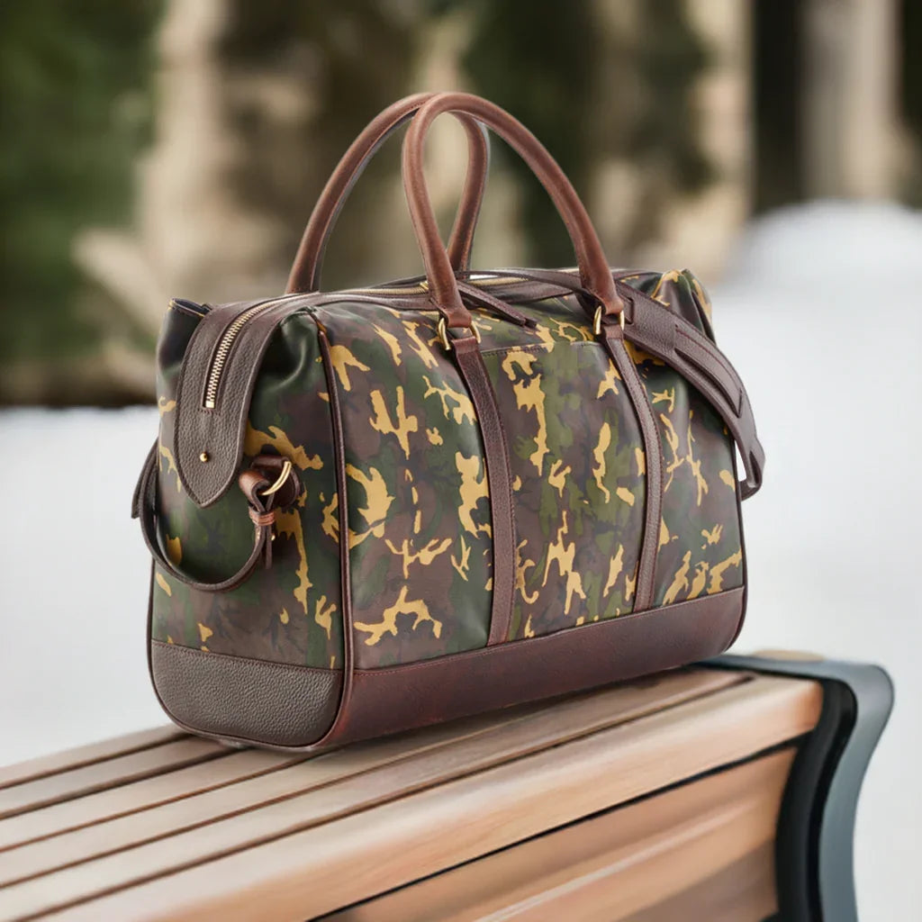 Wanderlust Leather Weekender Tan Camo lifestyle shot on wooden bench outdoors showing structured sheepskin silhouette and dark leather trim detail

