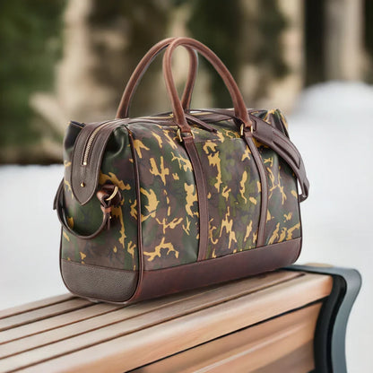 Wanderlust Leather Weekender Tan Camo lifestyle shot on wooden bench outdoors showing structured sheepskin silhouette and dark leather trim detail

