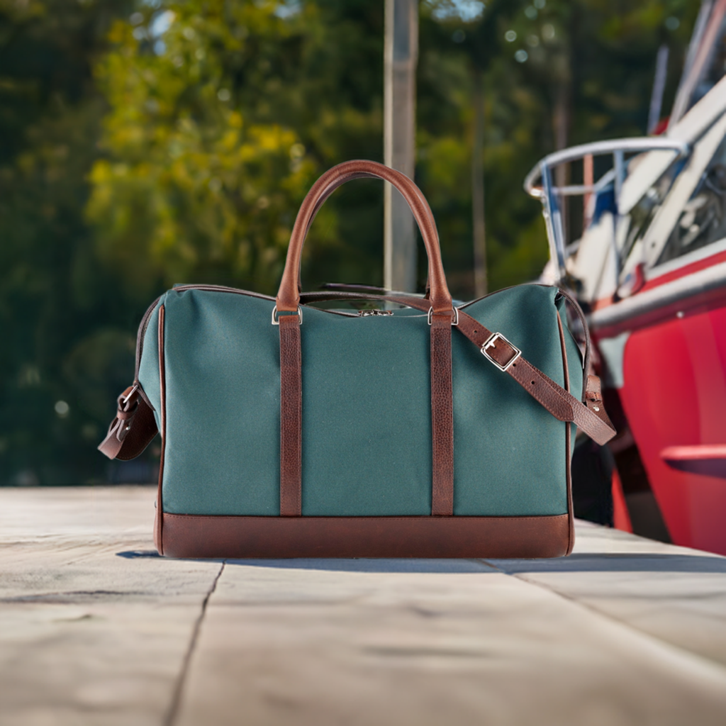 Wanderlust Weekender canvas duffel Classic Green lifestyle shot placed outdoors beside vintage red car showing travel-ready structured silhouette

