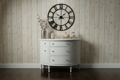A farmhouse-styled lifestyle view of the White Demilune Console Chest set against a rustic wood-planked wall with a large decorative wall clock.