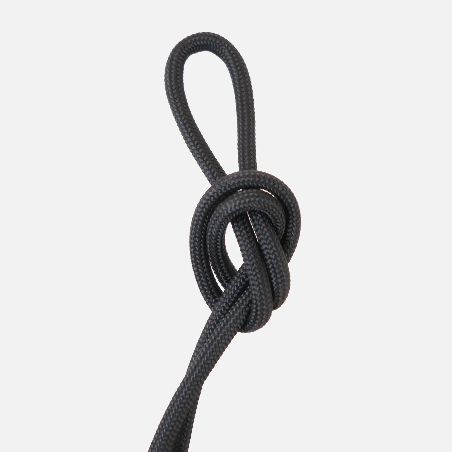 Jet black paracord knot detail of the Wrap hanging kit against a clean white background

