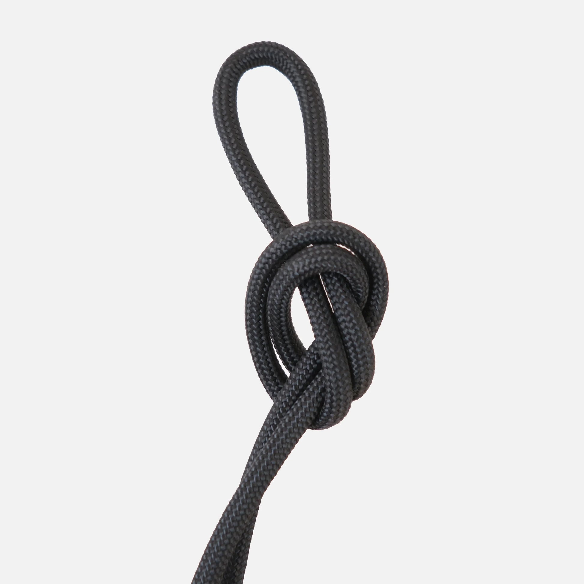 Jet black paracord knot detail of the Wrap hanging kit against a clean white background

